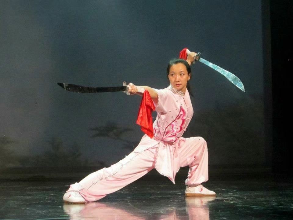 Wang Heng performing a broadsword form in pink silks